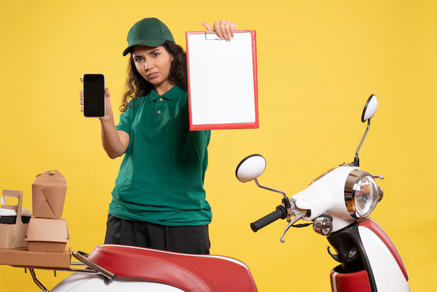 A girl holding a paper board and a cell phone.